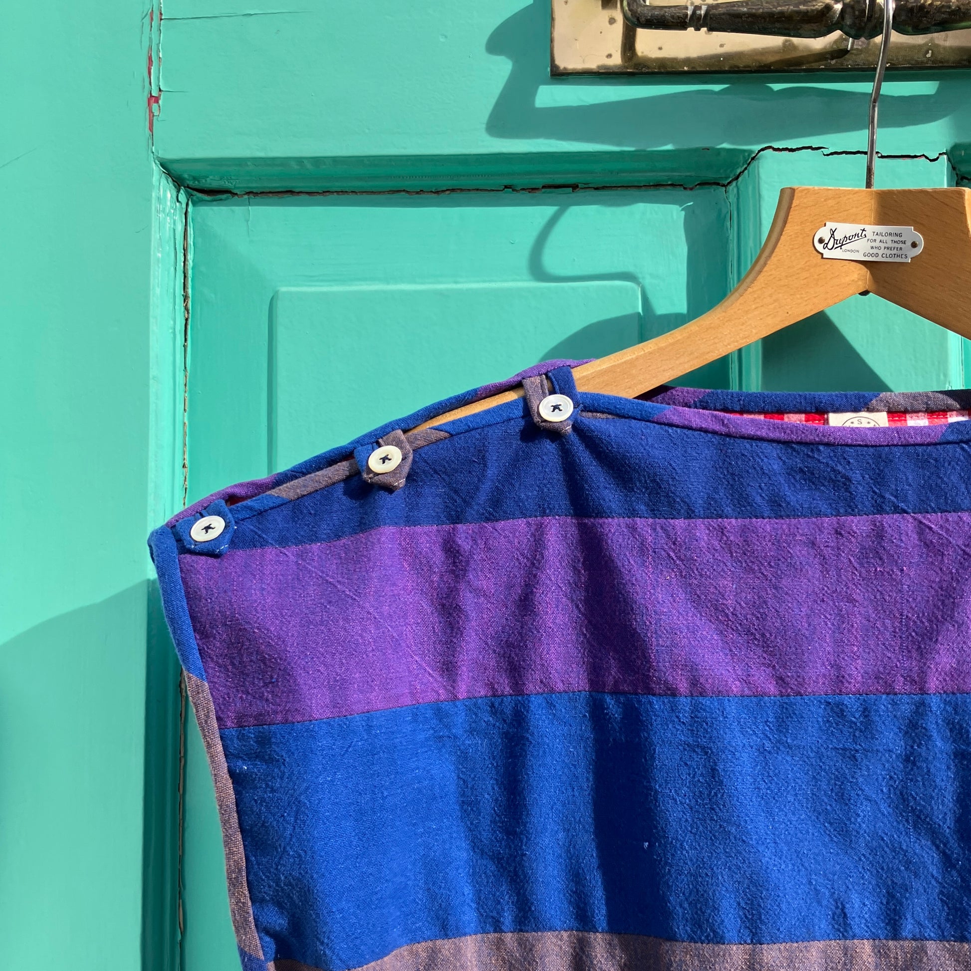 Blue and purple striped quilted top made from recycled fabrics, with a zip-up pocket