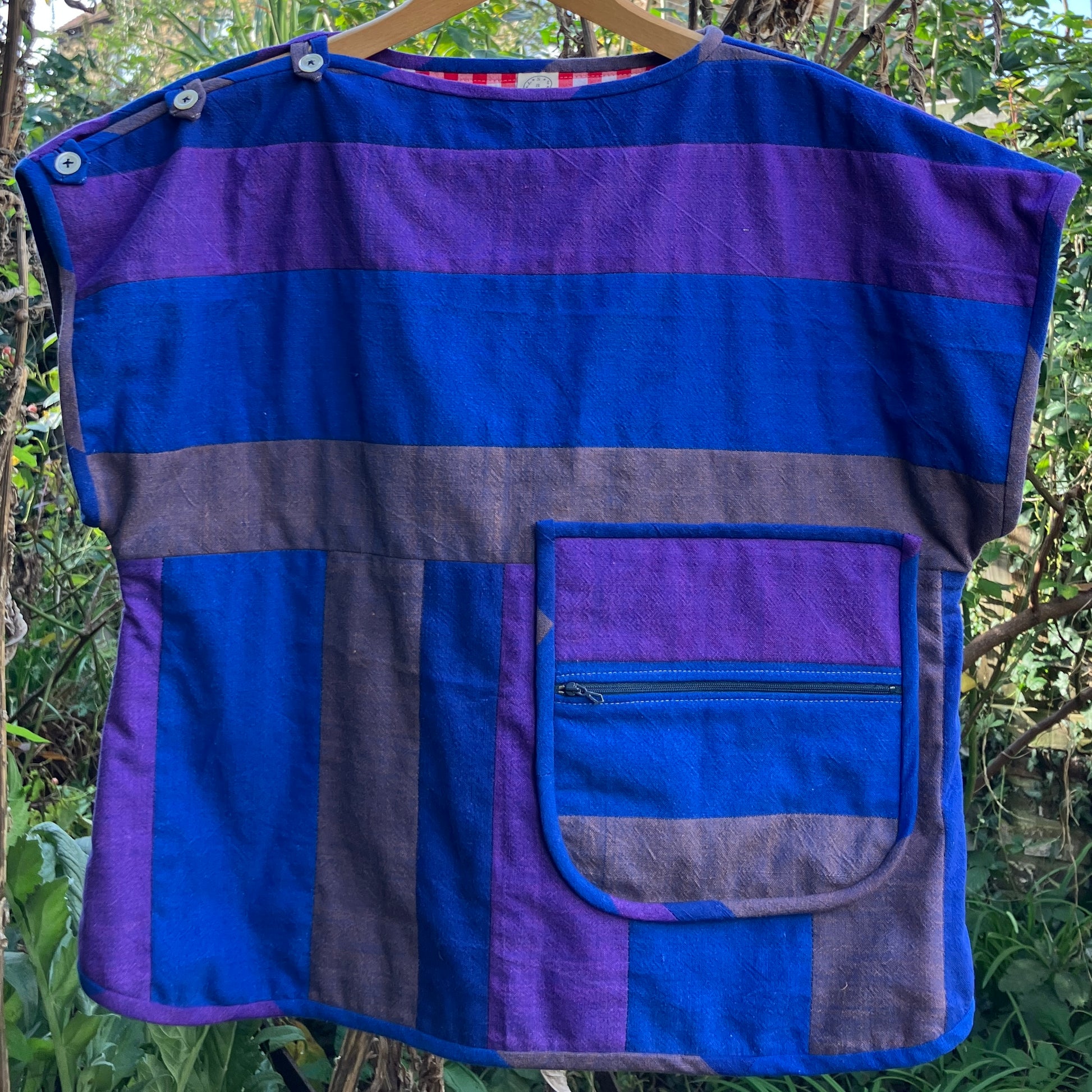 Blue and purple striped quilted top made from recycled fabrics, with a zip-up pocket