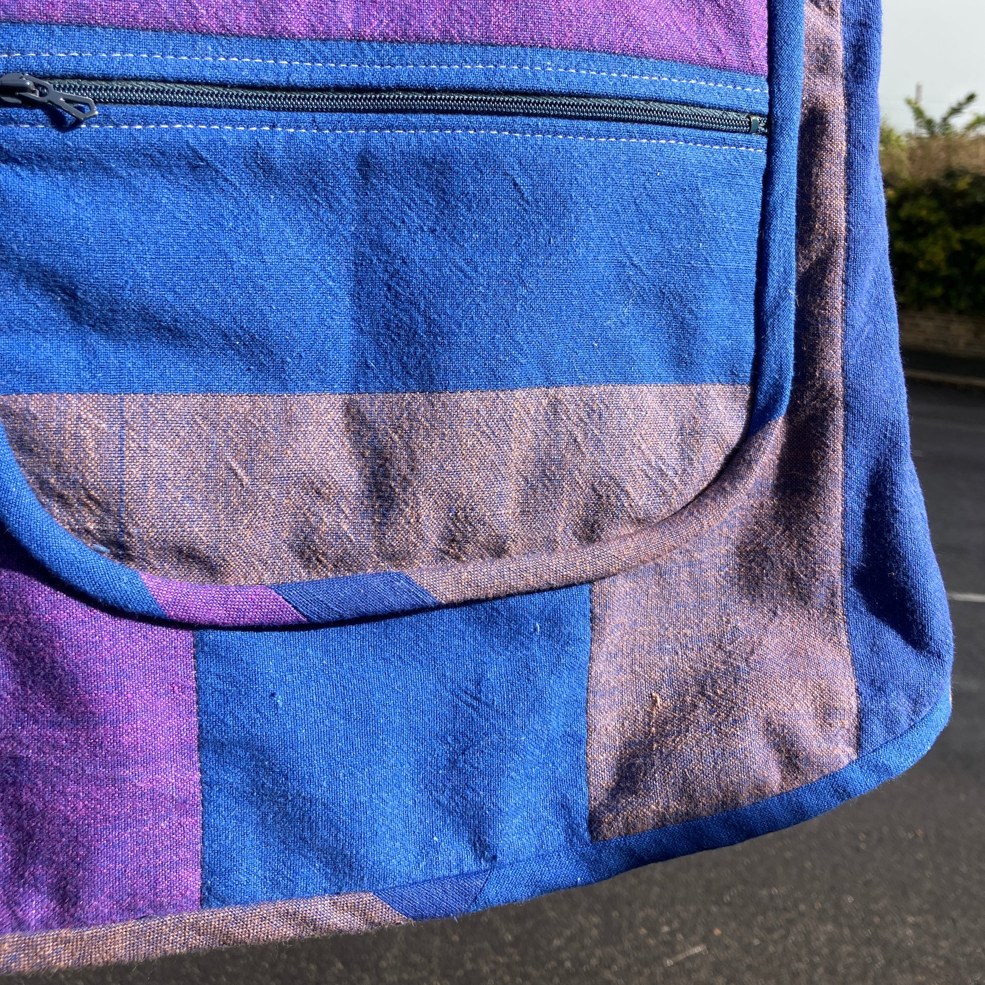 Blue and purple striped quilted top made from recycled fabrics, with a zip-up pocket