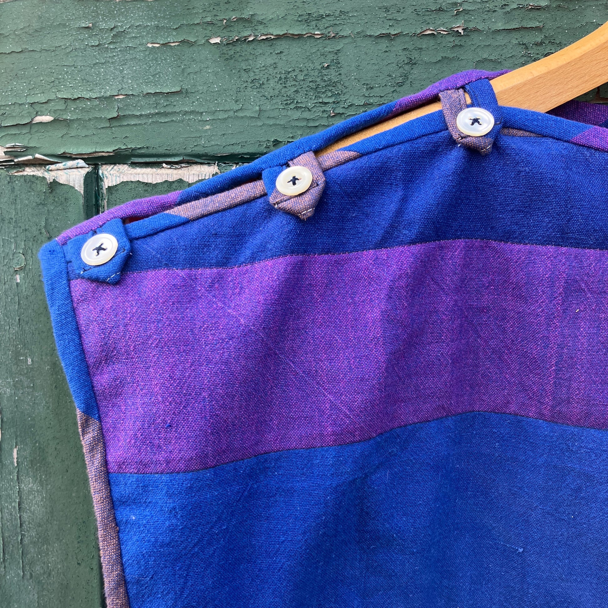 Blue and purple striped quilted top made from recycled fabrics, with a zip-up pocket