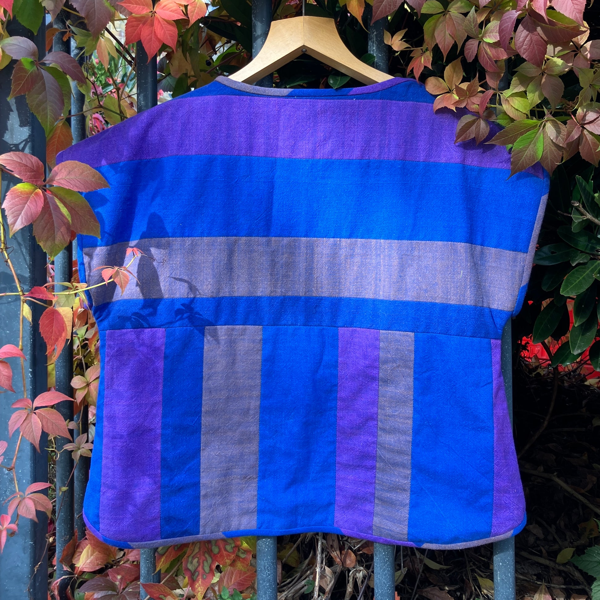Blue and purple striped quilted top made from recycled fabrics, with a zip-up pocket