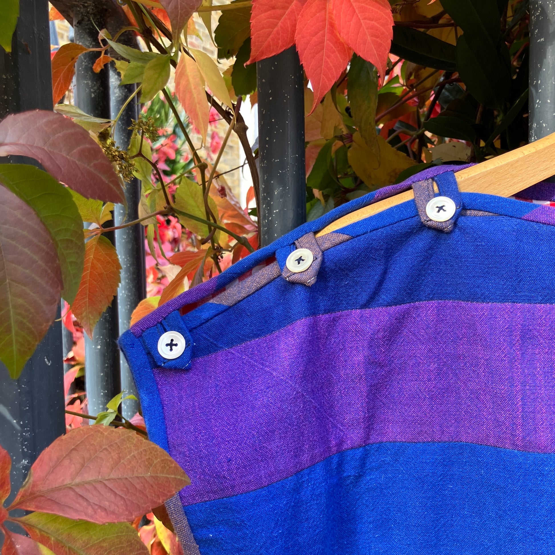 Blue and purple striped quilted top made from recycled fabrics, with a zip-up pocket