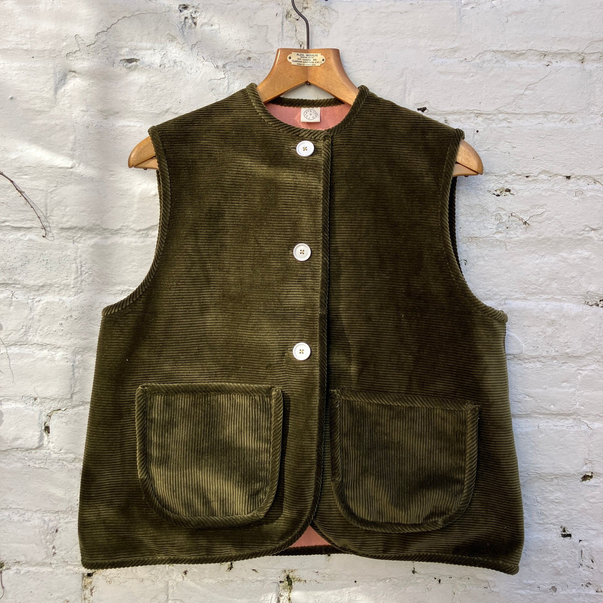 Reclaimed olive green corduroy vest with the wales going in a horizontal direction. Lined with dusky pink (possibly avocado dyed) cotton