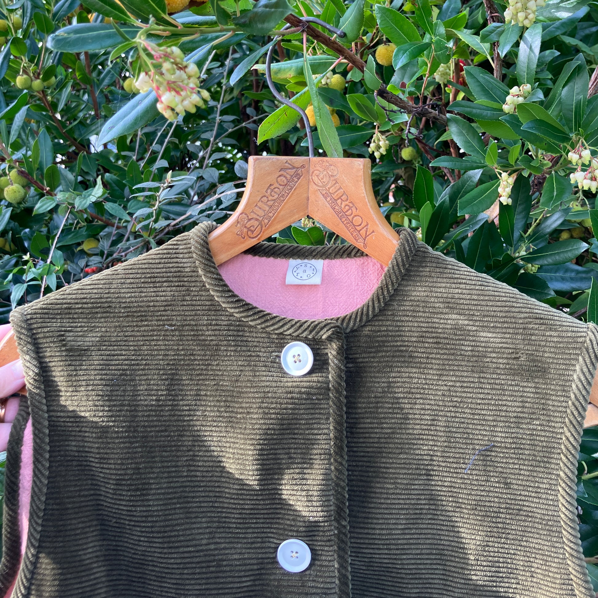 Reclaimed olive green corduroy vest with the wales going in a horizontal direction. Lined with dusky pink (possibly avocado dyed) cotton