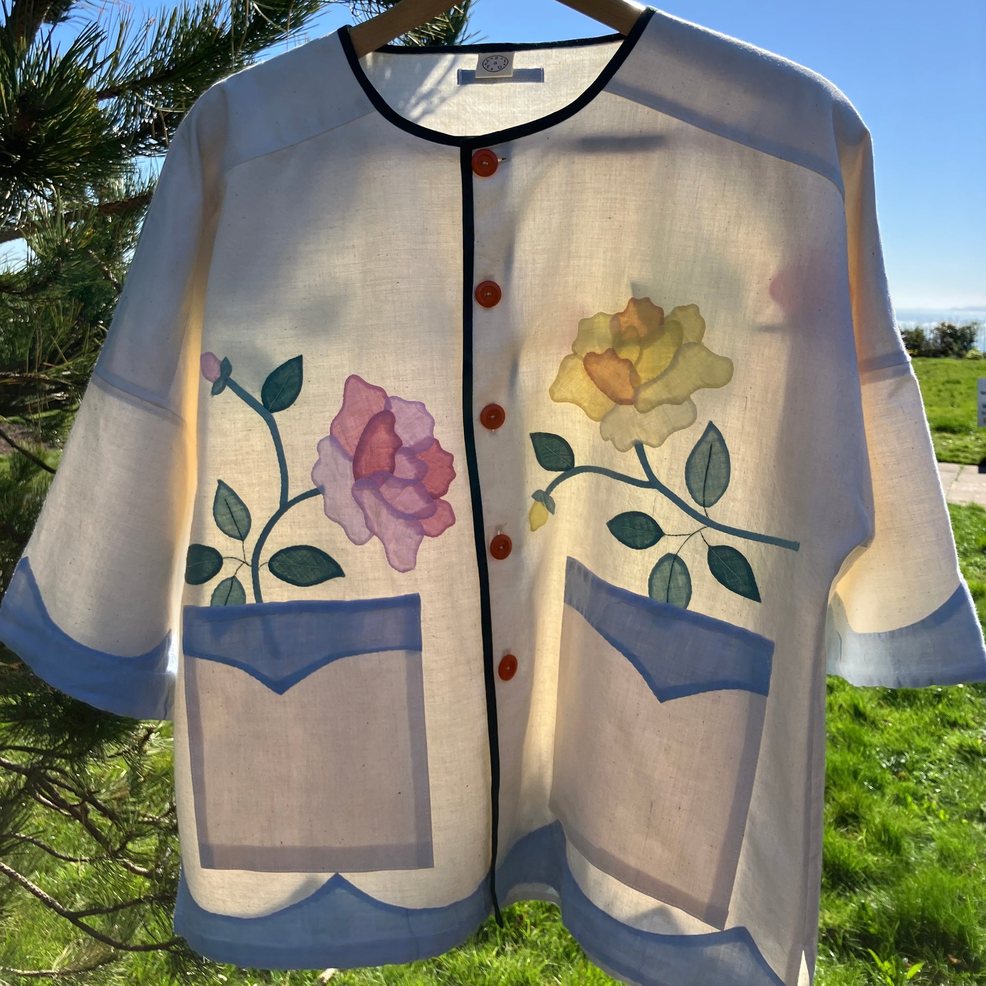 Pretty boxy top with pastel-coloured floral appliqué, made from a vintage cotton bedspread with scalloped edges