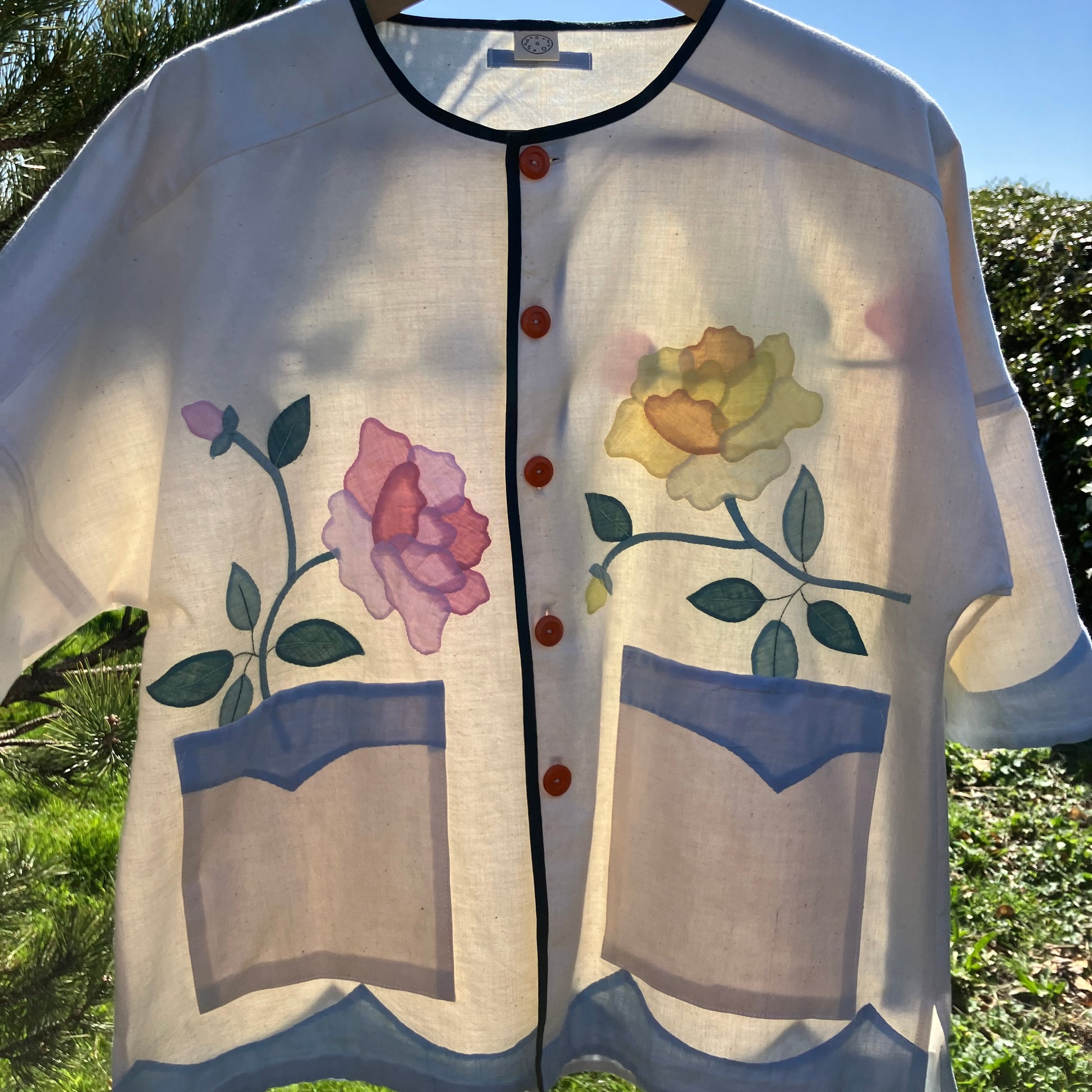 Pretty boxy top with pastel-coloured floral appliqué, made from a vintage cotton bedspread with scalloped edges