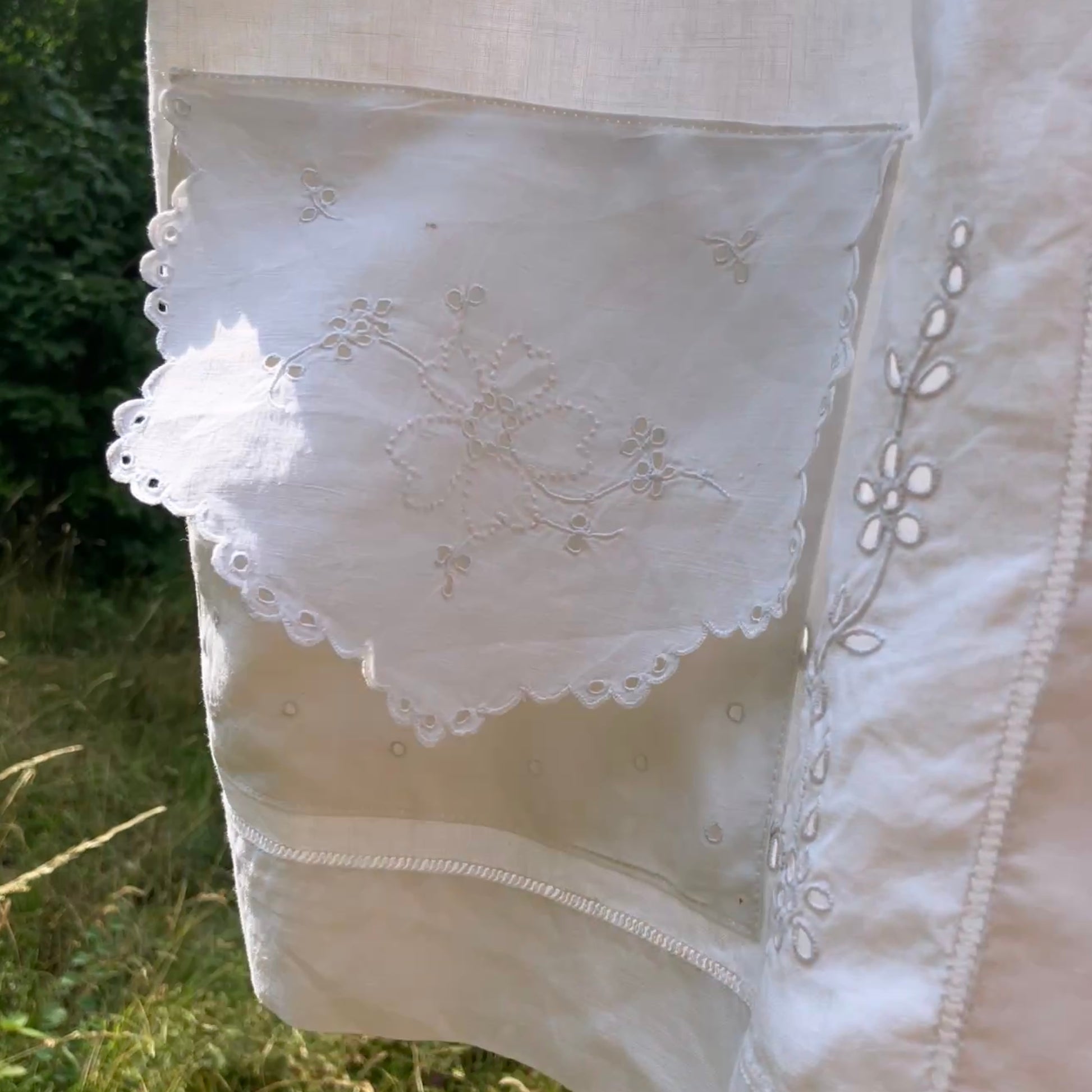 Close-up of a white embroidered garment with a natural background