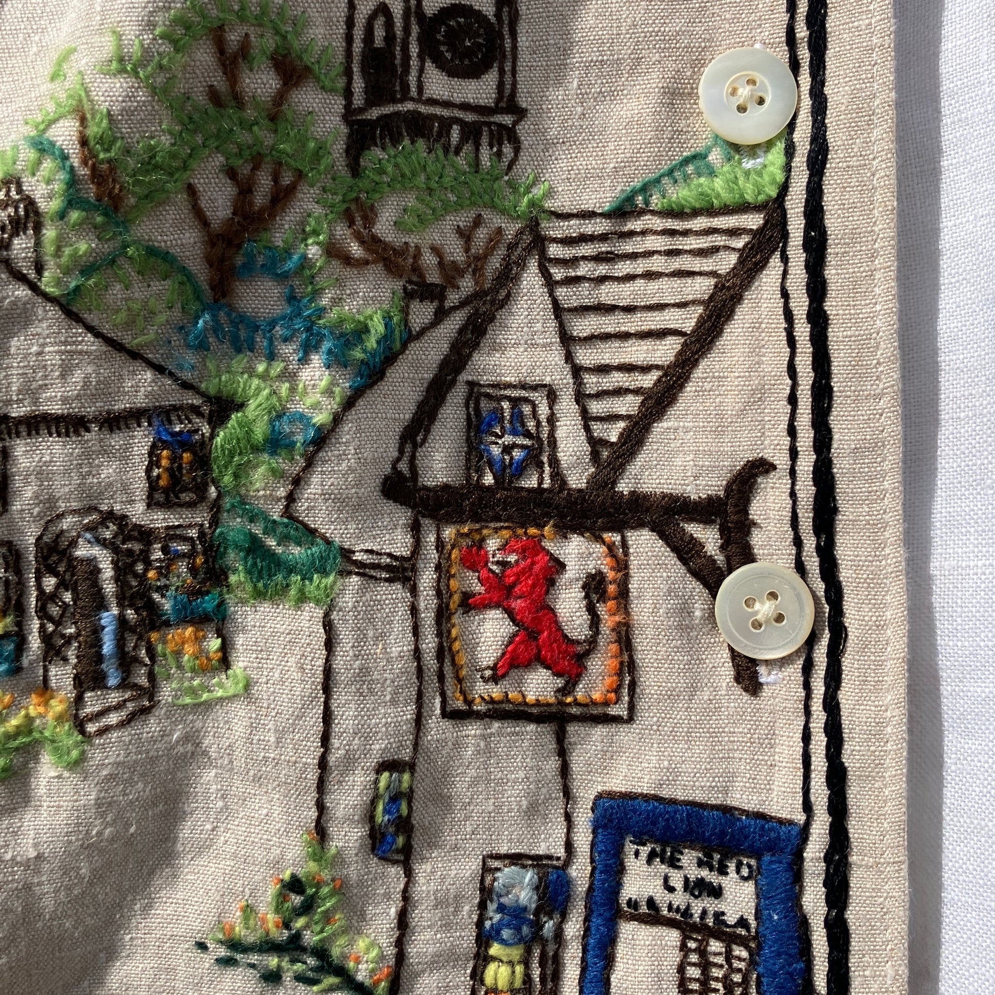 Recycled fabric shirt with embroidery depicting a village pub