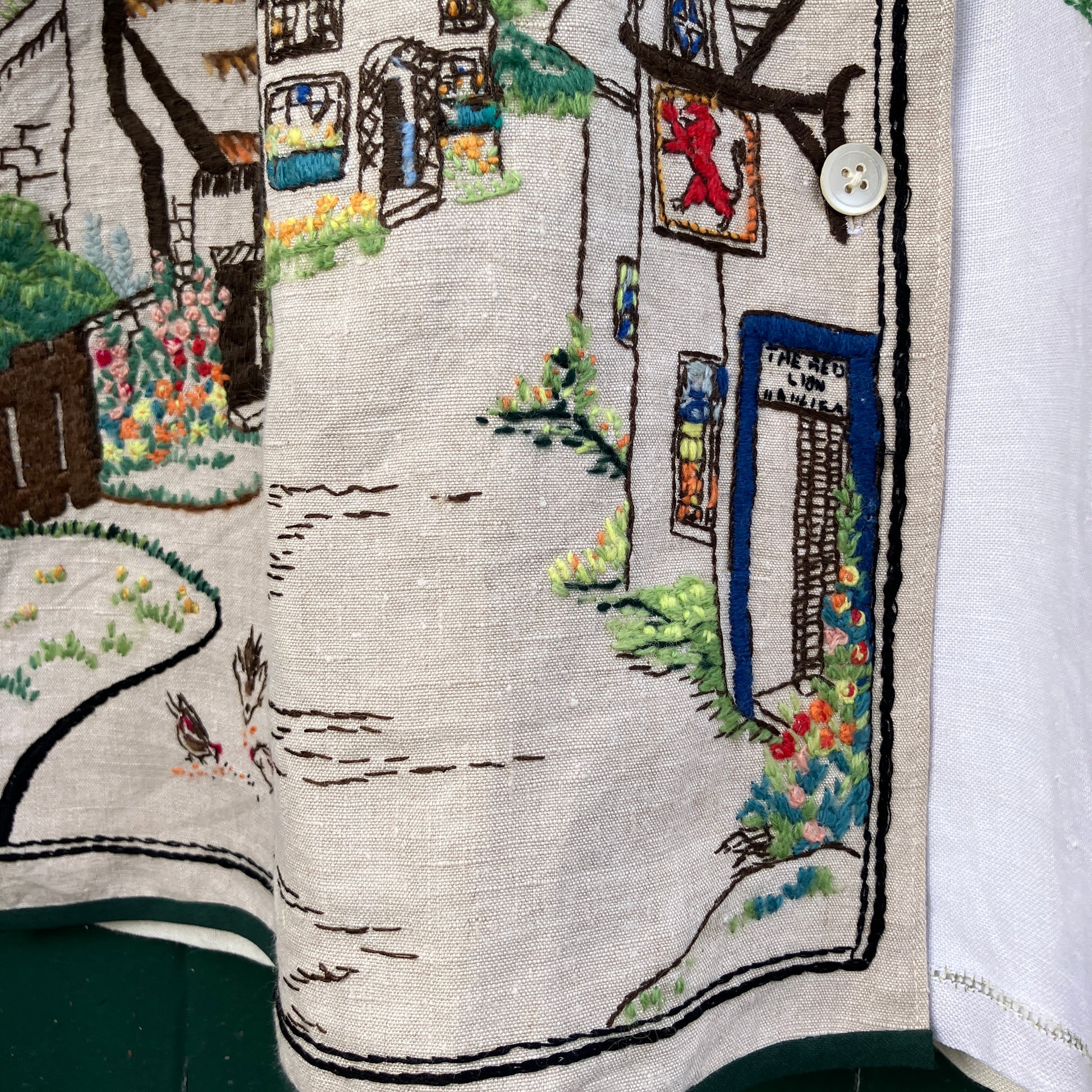 Recycled fabric shirt with embroidery depicting a village pub