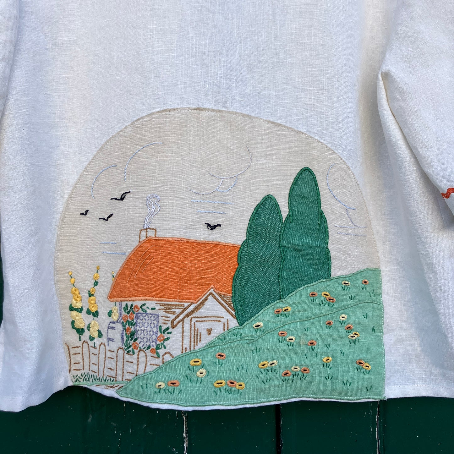 Simple linen shirt/jacket with patch pockets, ric-rac trim and a 1930s embroidered cottagecore scene appliquéd on to the back.