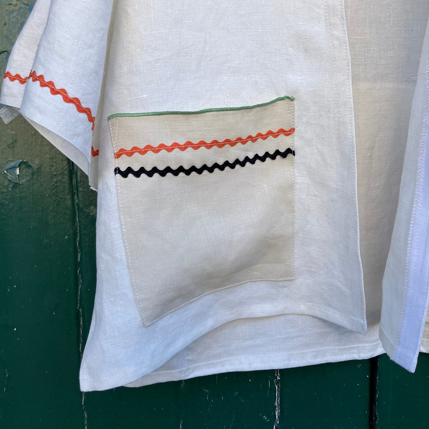Simple linen shirt/jacket with patch pockets, ric-rac trim and a 1930s embroidered cottagecore scene appliquéd on to the back.