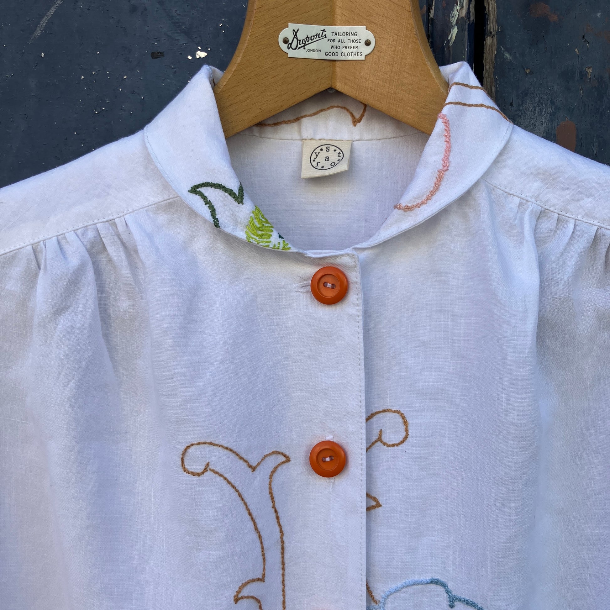 Blouse made from a recycled floral embroidered tablecloth, with cutaway collar and orange buttons