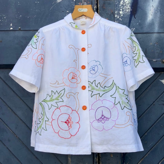 Blouse made from a recycled floral embroidered tablecloth, with cutaway collar and orange buttons