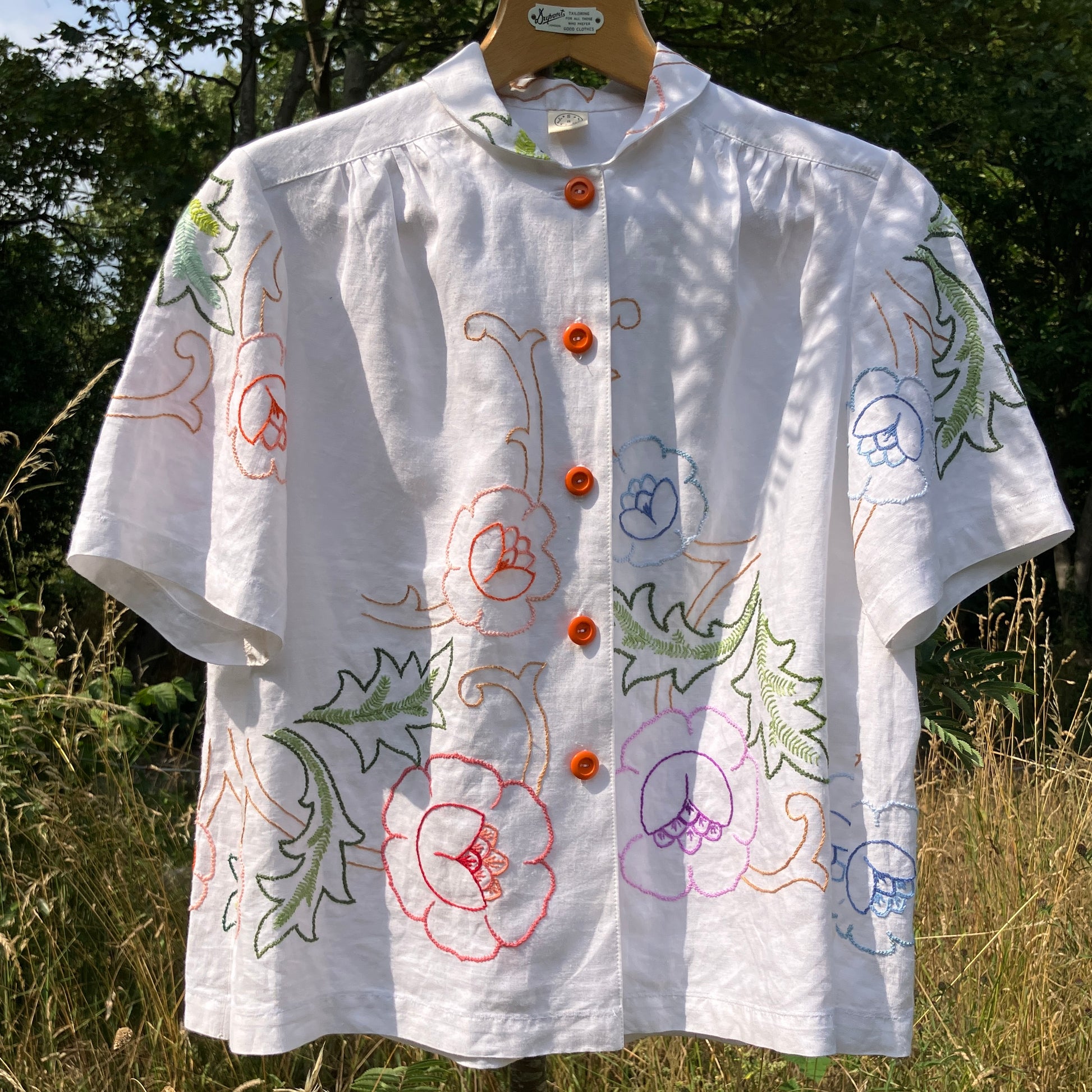 Blouse made from a recycled floral embroidered tablecloth, with cutaway collar and orange buttons
