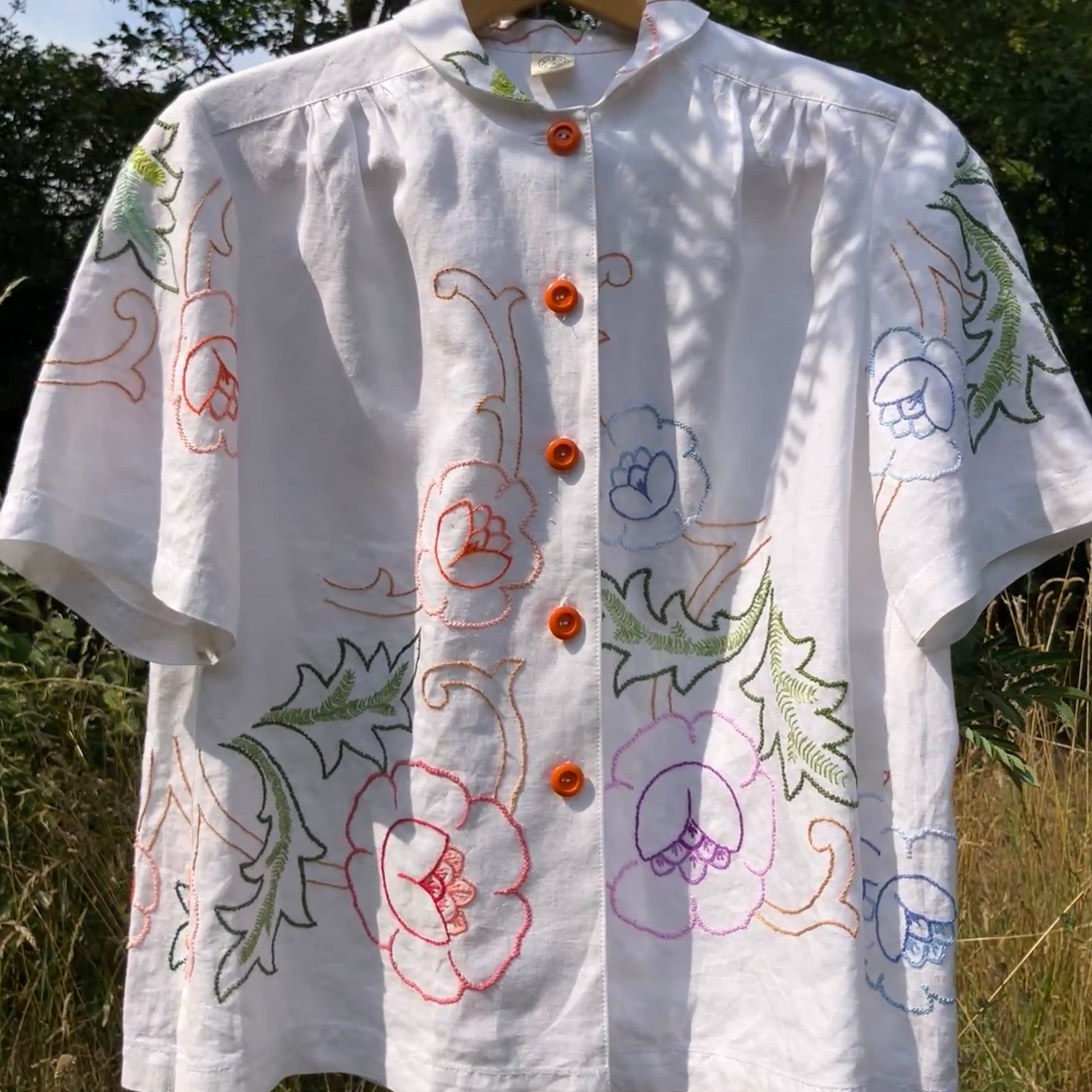 Blouse made from a recycled floral embroidered tablecloth, with cutaway collar and orange buttons
