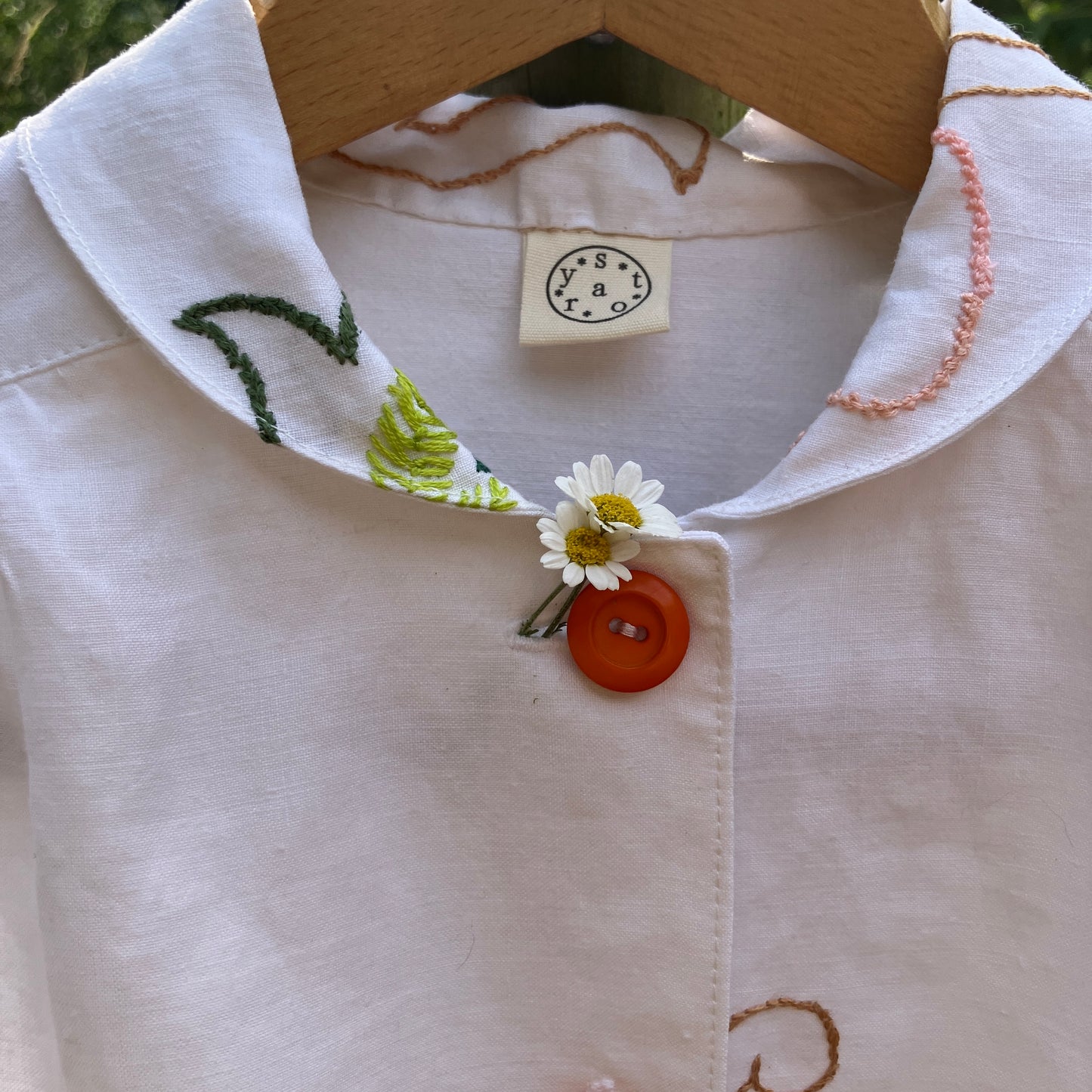 Blouse made from a recycled floral embroidered tablecloth, with cutaway collar and orange buttons