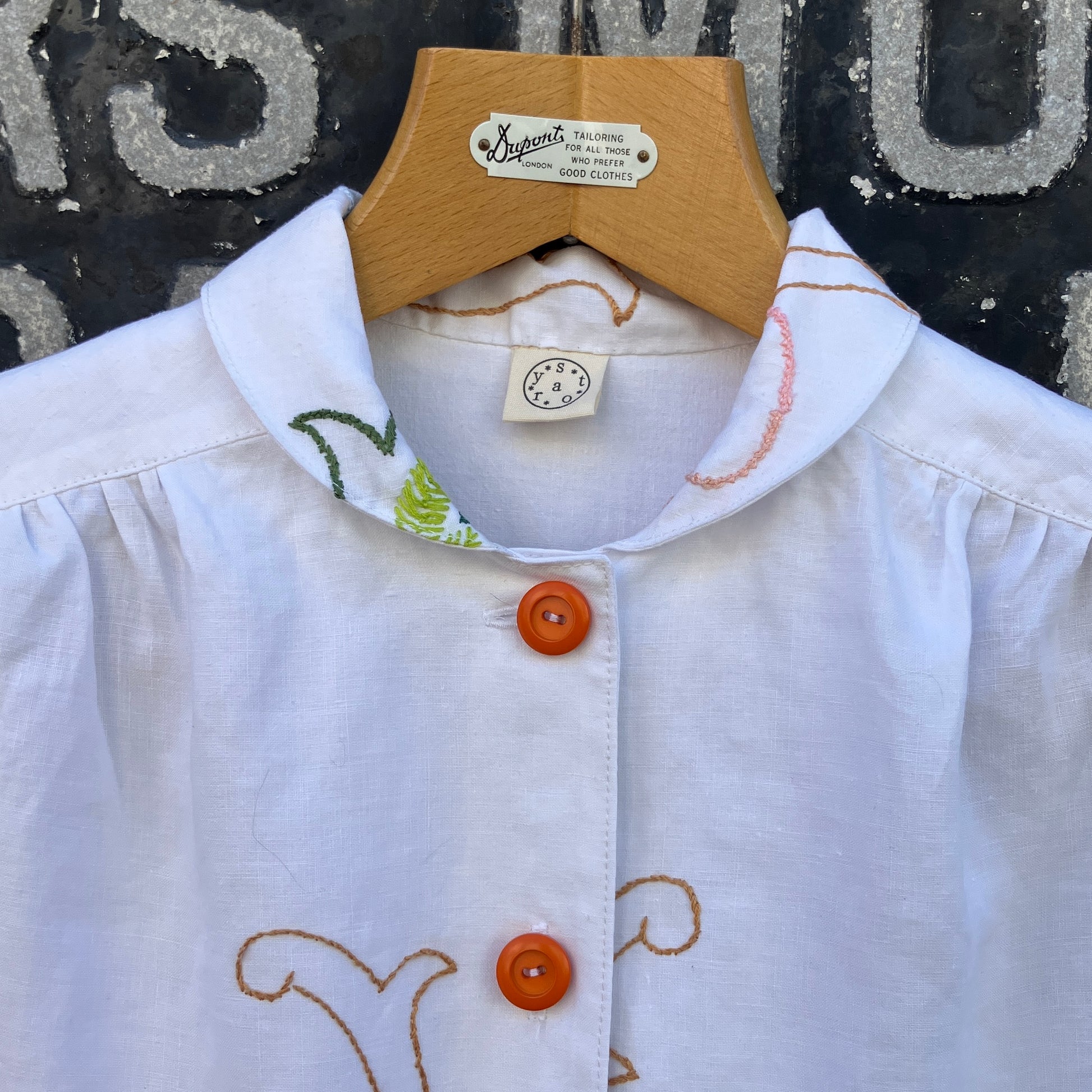 Blouse made from a recycled floral embroidered tablecloth, with cutaway collar and orange buttons
