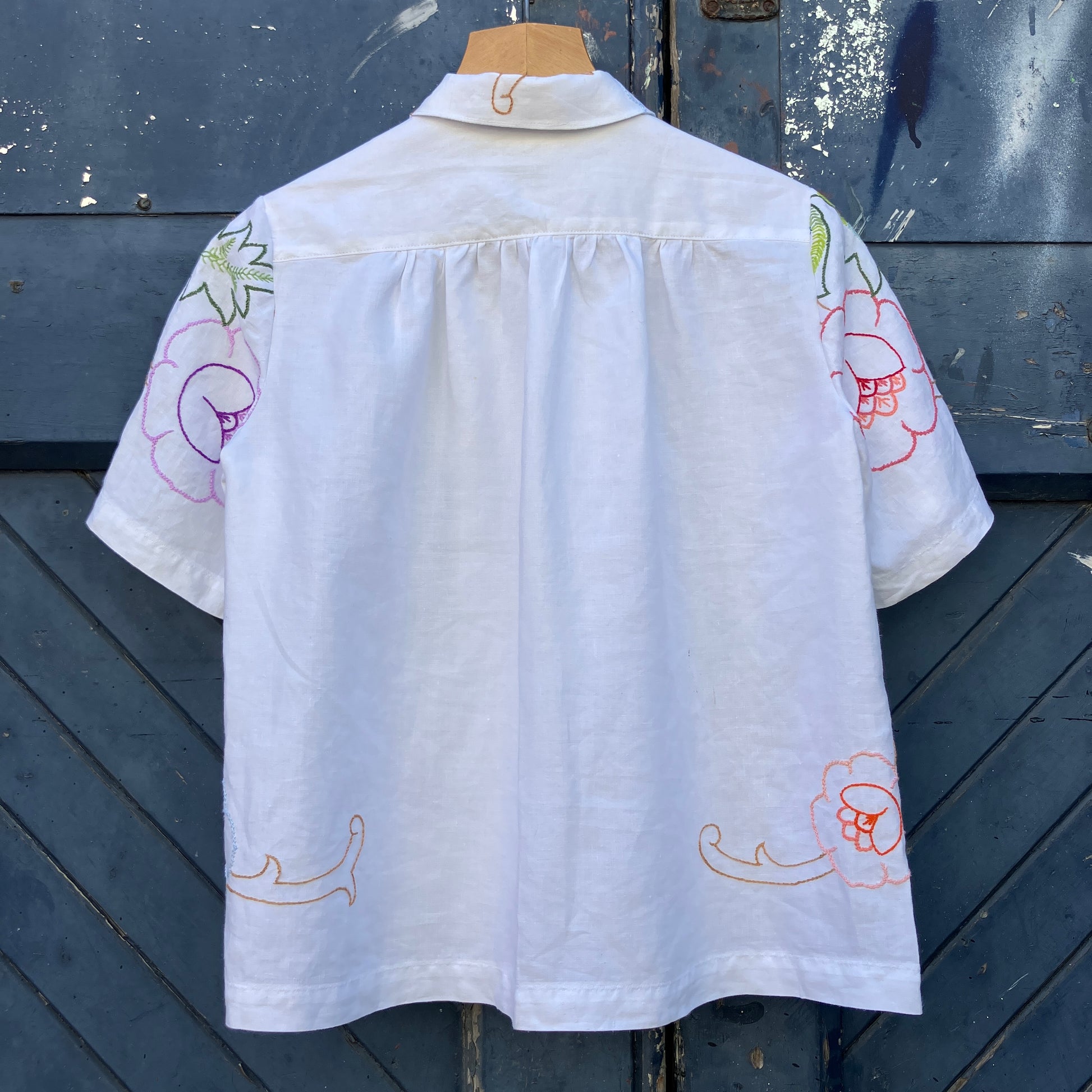 Blouse made from a recycled floral embroidered tablecloth, with cutaway collar and orange buttons