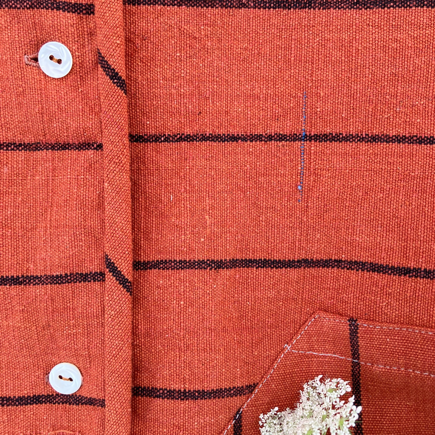 A terracotta orange boxy top with thin black stripes