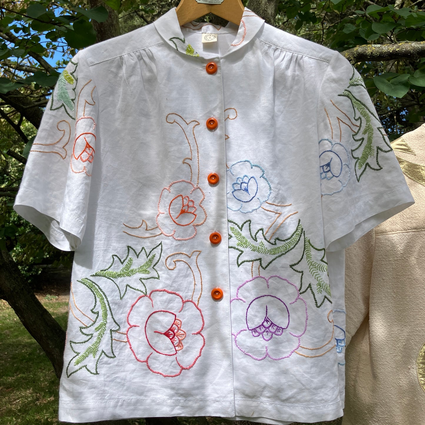 Blouse made from a recycled floral embroidered tablecloth, with cutaway collar and orange buttons