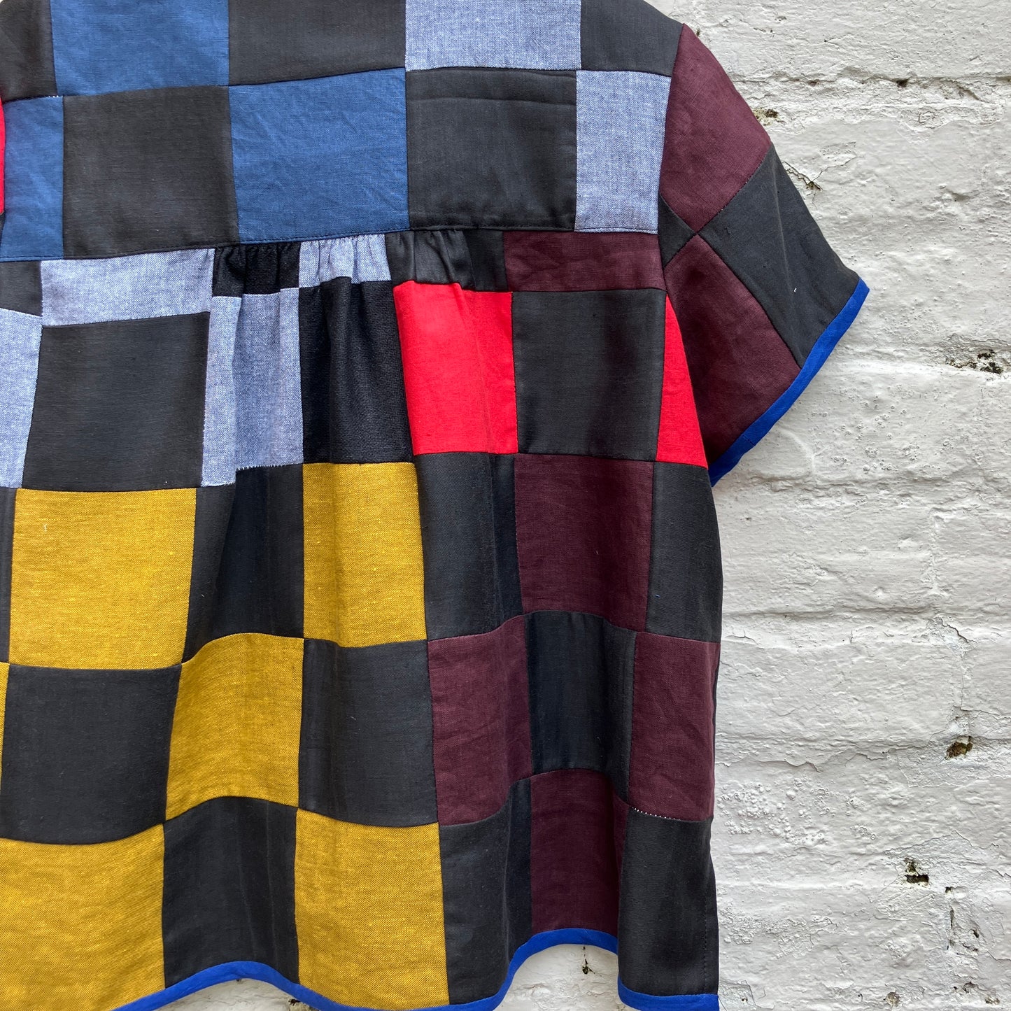 Shirt made from a patchwork of cotton and linen offcuts in black and muted brights.