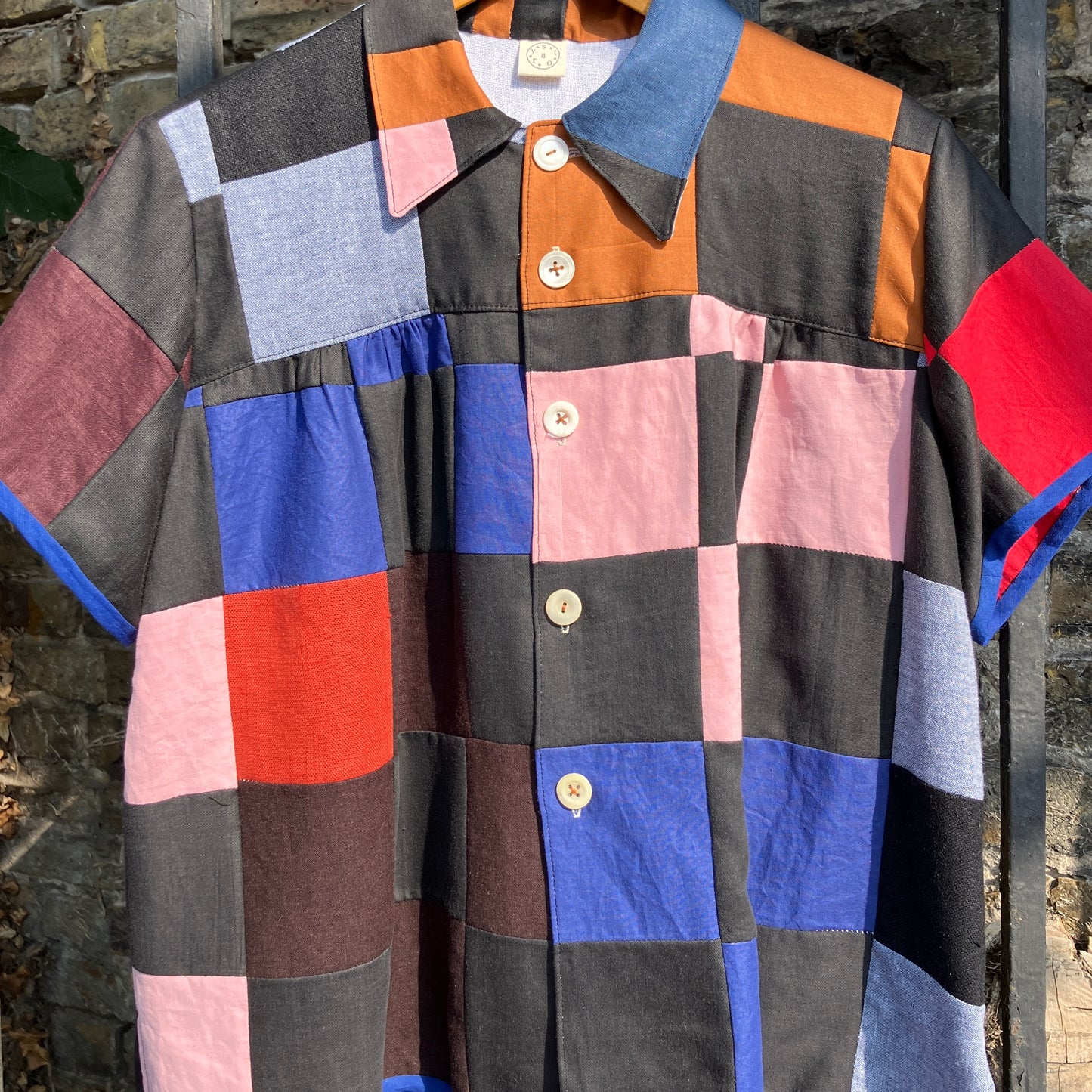 Shirt made from a patchwork of cotton and linen offcuts in black and muted brights.