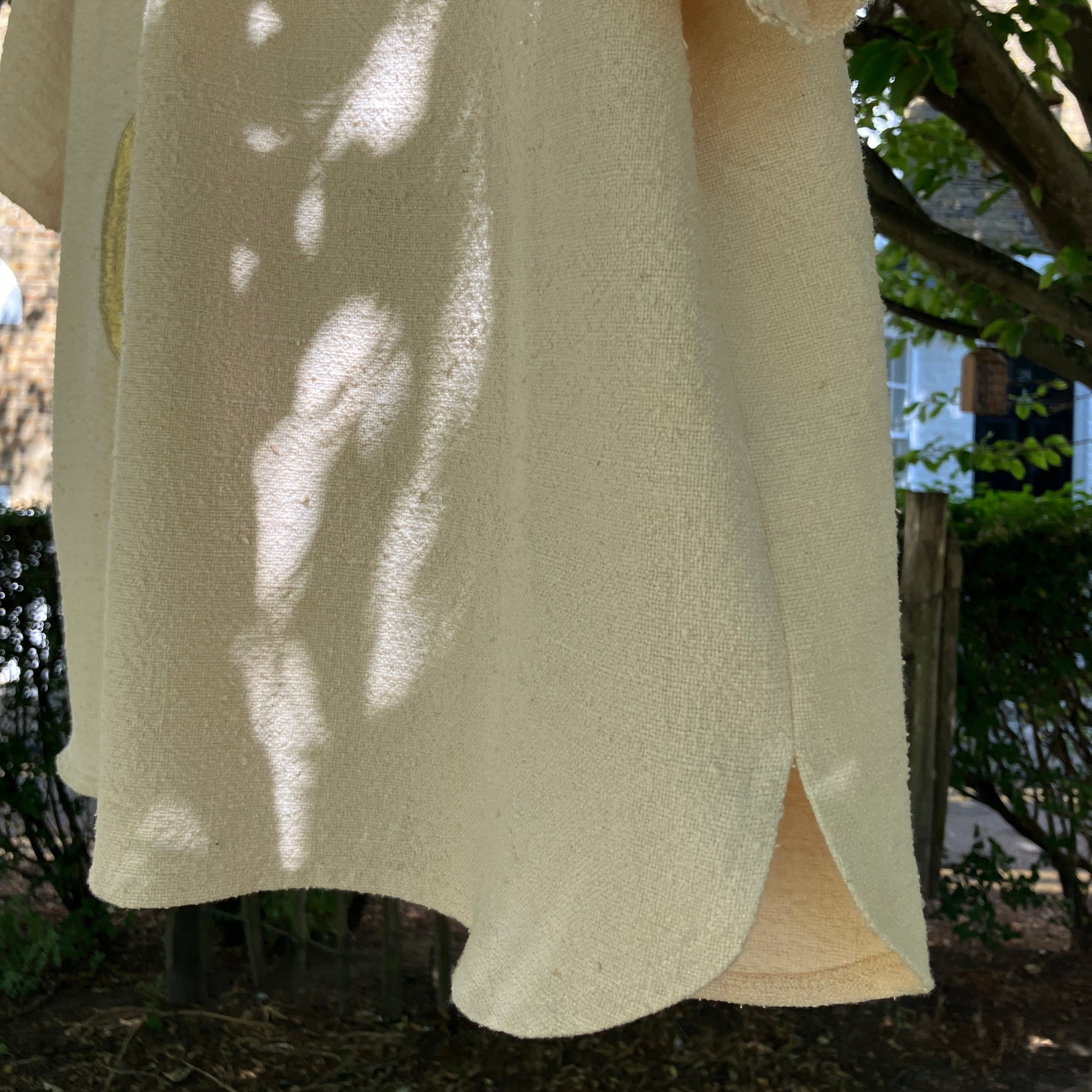neutral-coloured raw silk smock with gold weather-themed appliqué