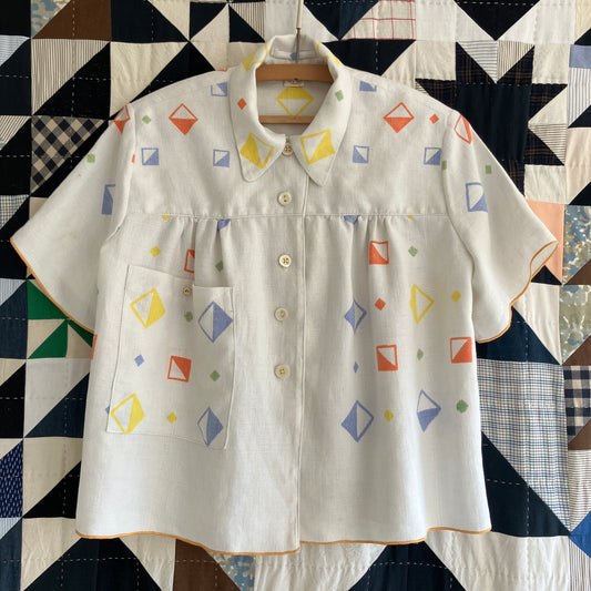 One-of-a-kind shirt handmade from a beautifully soft reclaimed off-white linen tablecloth with a cool geometric print in yellow, orange, green and lilac-y blue