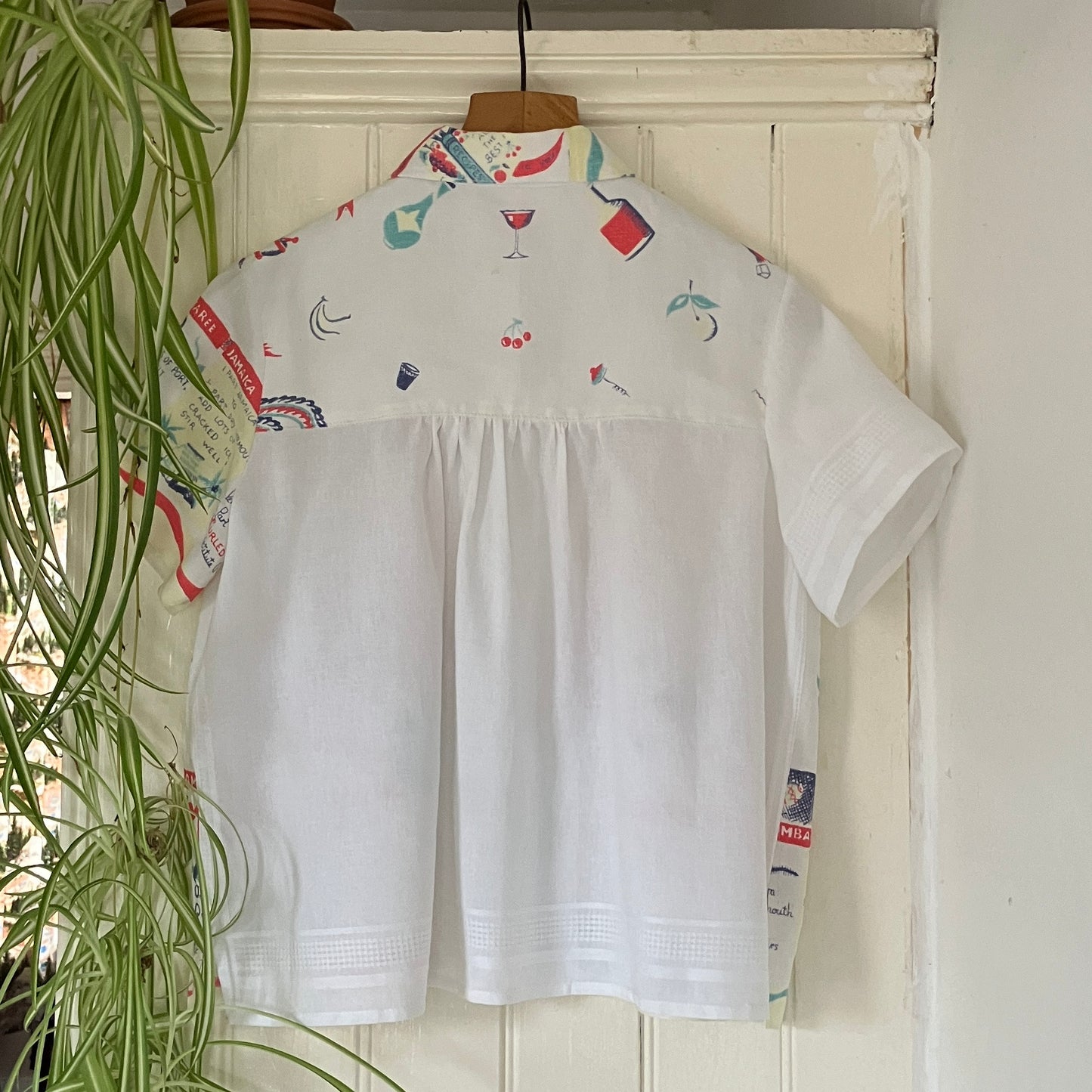A shirt handmade from a vintage 'cocktails' tablecloth, featuring recipes and illustrations (back view)