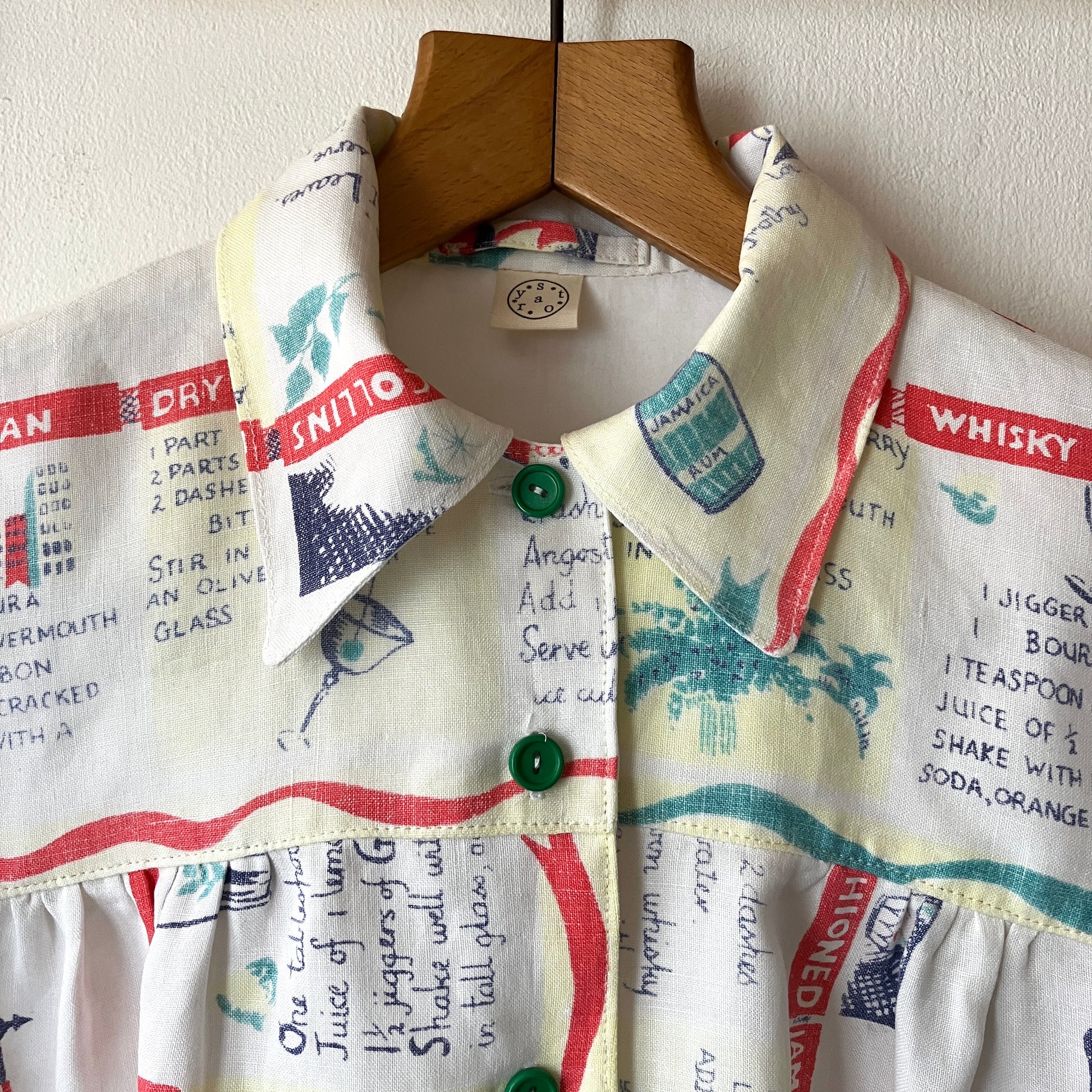 A shirt handmade from a vintage 'cocktails' tablecloth, featuring recipes and illustrations (close-up of collar)