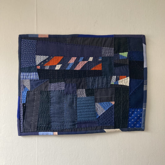 Wallhanging made from precious blue-coloured scraps patchworked together and quilted in an improv fashion